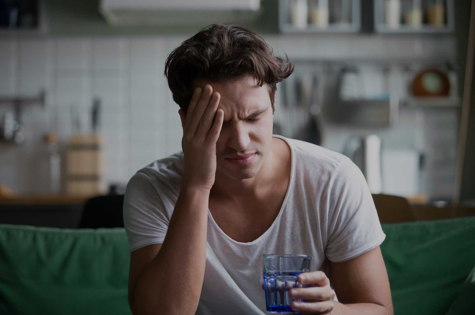 Future Search Trials Migrain Study Austin Dallas, Texas. Man in migraine pain holding glass of water.